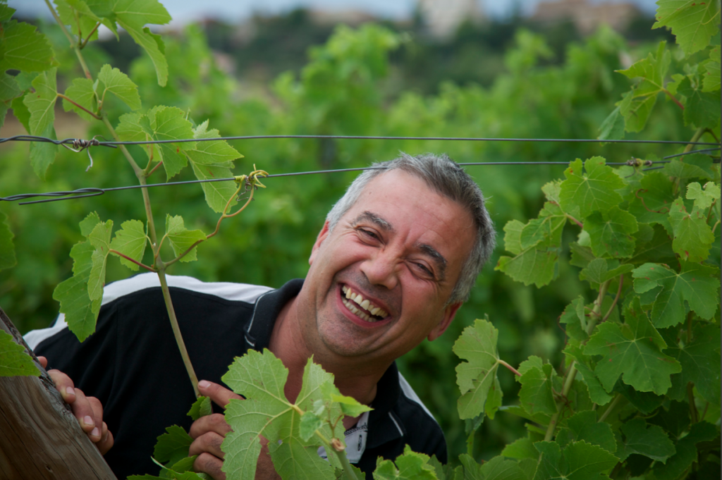 Der Winzer Rémy Soulié steht lachend inmitten seiner Reben